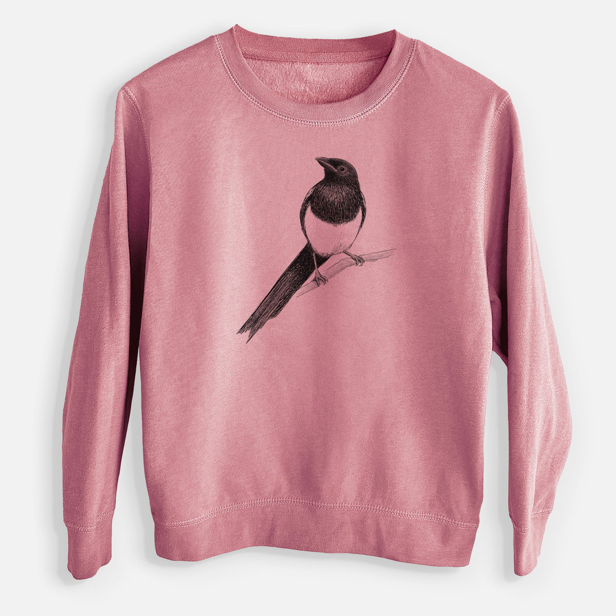 Mauve pink youth crewneck sweatshirt laid flat, printed with a detailed black ink sketch of a black-billed magpie perched on a branch with its long tail.