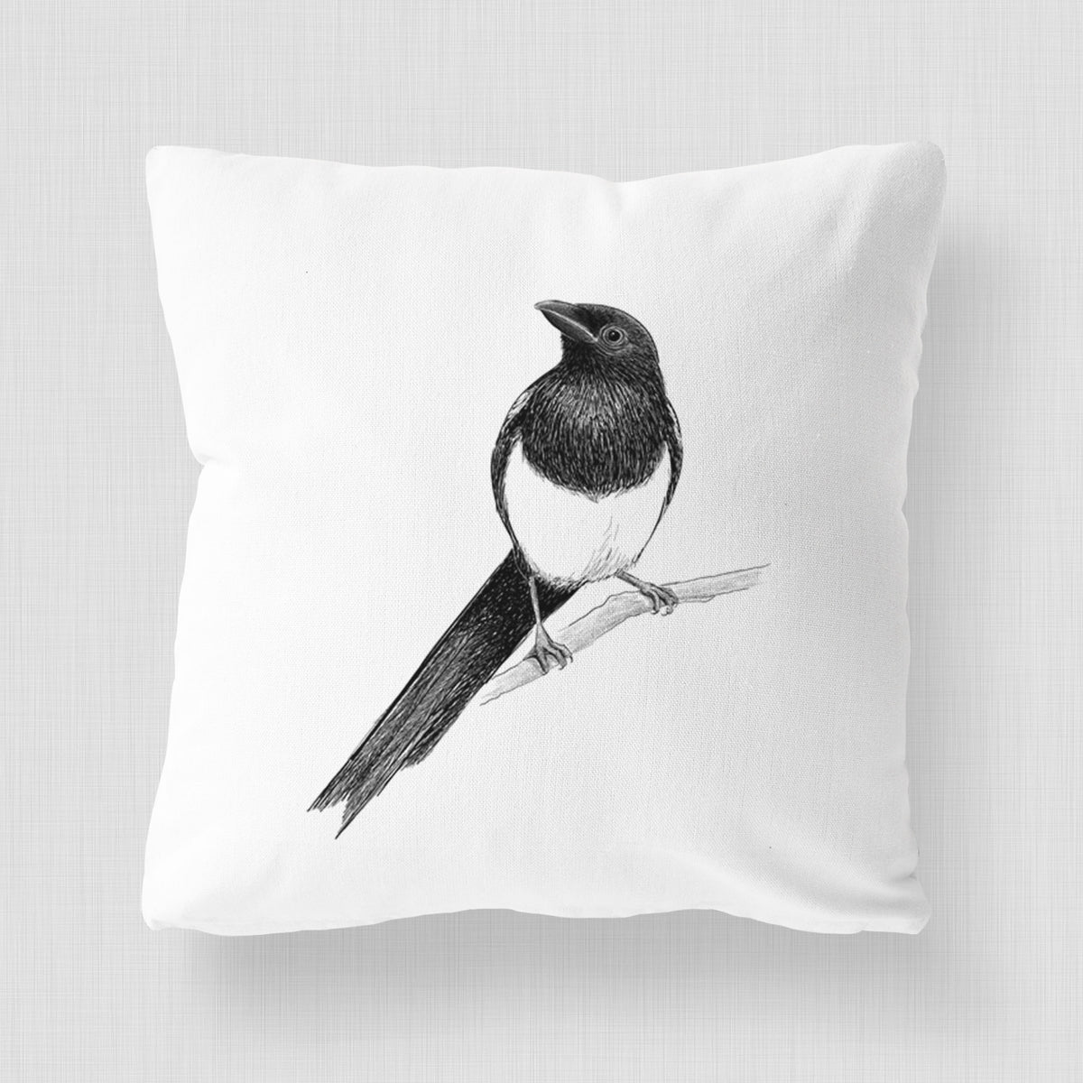 White pillow cover printed with a detailed black ink sketch of a black-billed magpie perched on a branch with its long tail.
