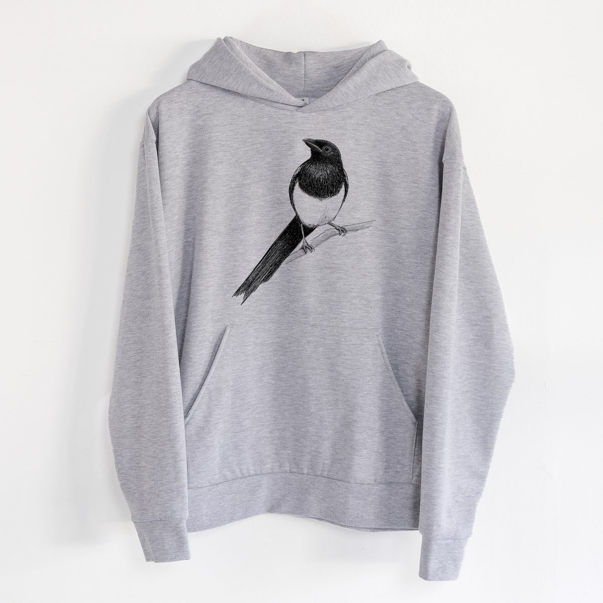 Black-billed Magpie - Pica hudsonia - Statement Midweight Hoodie in Heather Grey, hanging on a white wall, with a front kangaroo pocket and no drawcords.