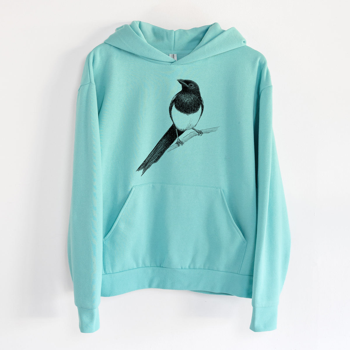 Black-billed Magpie - Pica hudsonia - Statement Midweight Hoodie in Seafoam, hanging on a white wall, with a front kangaroo pocket and no drawcords.