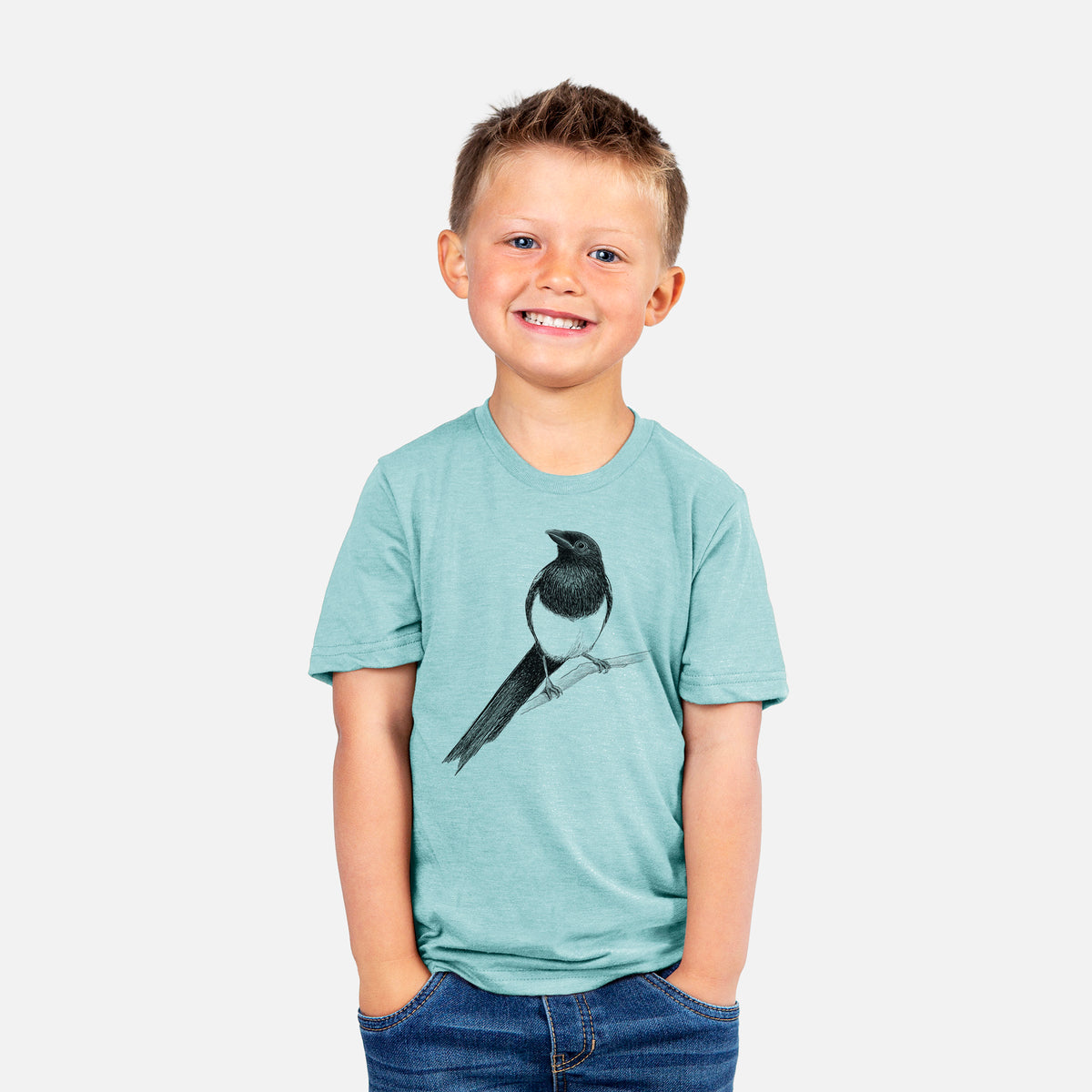 Smiling boy wearing a youth t-shirt printed with a detailed black ink sketch of a black-billed magpie perched on a branch with its long tail.