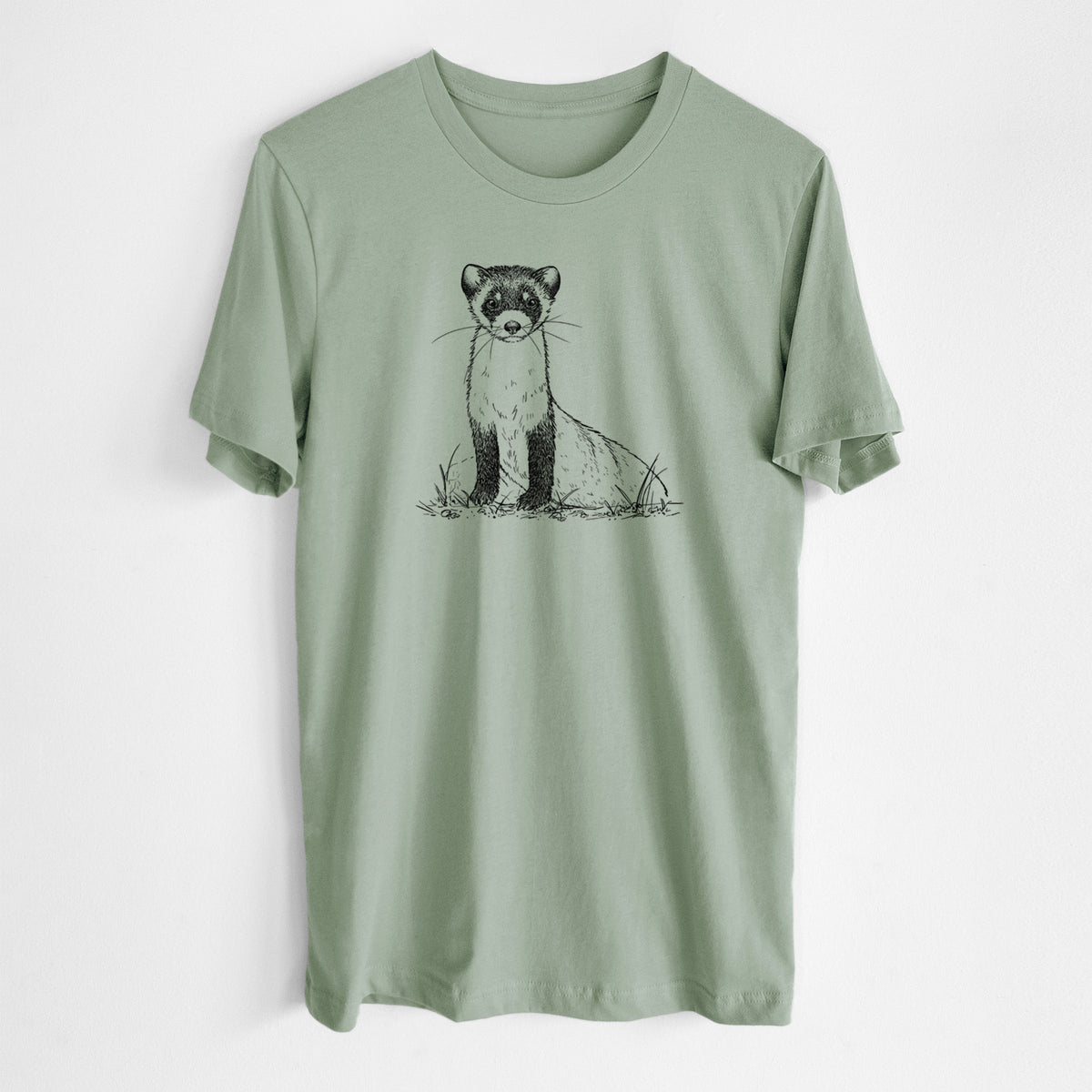 Sage green lightweight cotton t-shirt laid flat, printed with a detailed black ink illustration of a black-footed ferret sitting on the ground.