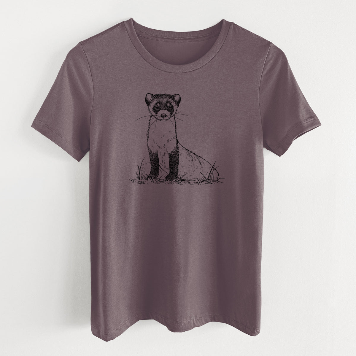 Purple storm women's relaxed fit cotton t-shirt laid flat, printed with a detailed black ink illustration of a black-footed ferret sitting on the ground.