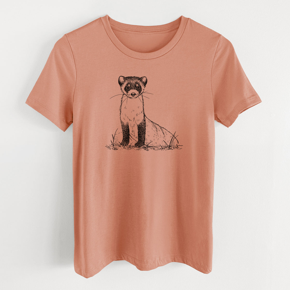 Terracotta orange women's relaxed fit cotton t-shirt laid flat, printed with a detailed black ink illustration of a black-footed ferret sitting on the ground.