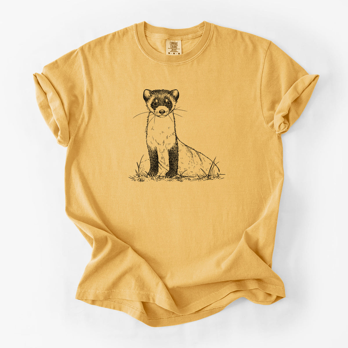 Golden wheat yellow Comfort Colors t-shirt laid flat, printed with a detailed black ink illustration of a black-footed ferret sitting on the ground.