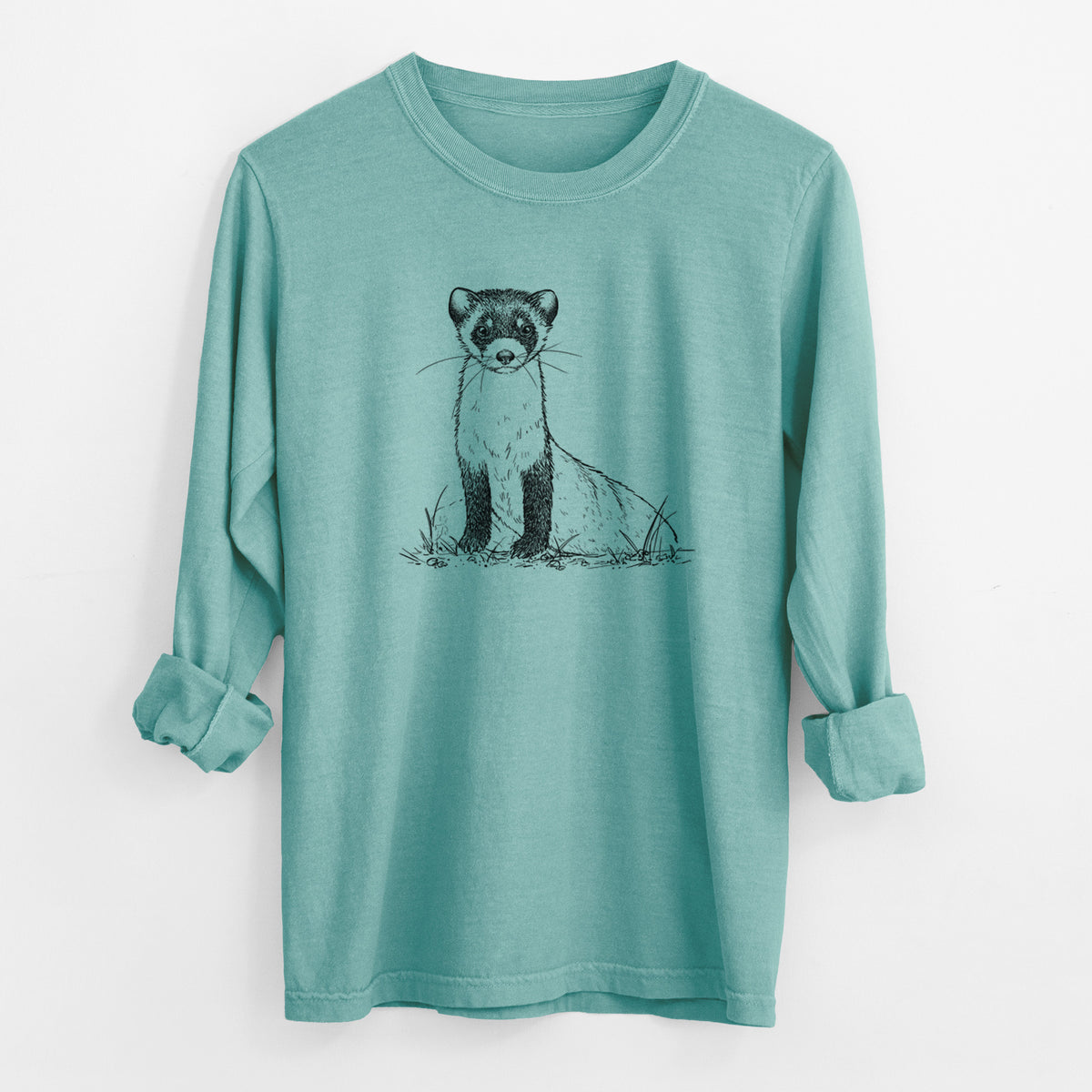 Reef green Comfort Colors long sleeve shirt laid flat with the cuffs rolled, printed with a detailed black ink illustration of a black-footed ferret sitting on the ground.