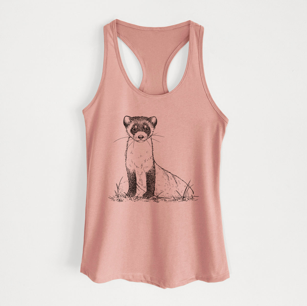 Desert pink women's racerback tank top laid flat, printed with a detailed black ink illustration of a black-footed ferret sitting on the ground.