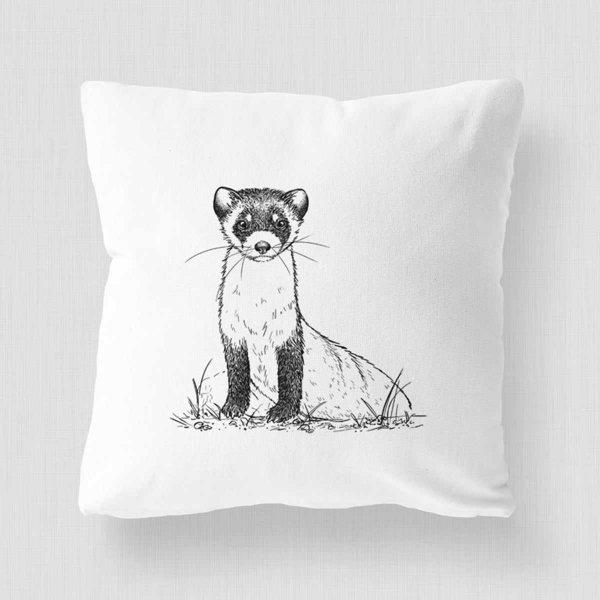 White pillow cover printed with a detailed black ink illustration of a black-footed ferret sitting on the ground.
