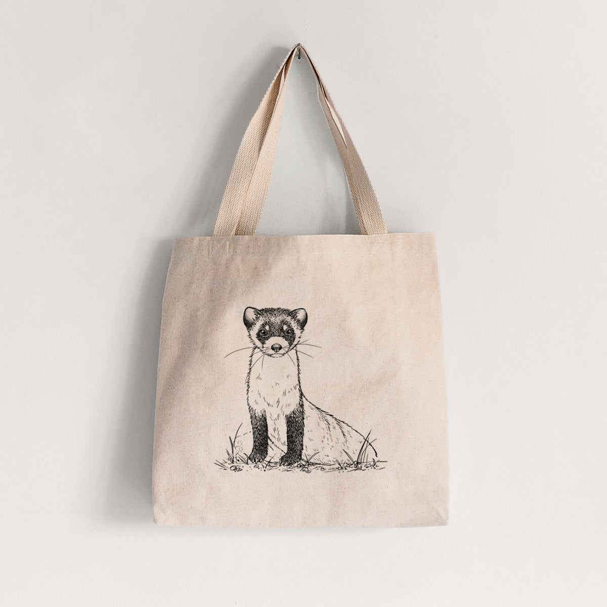 Natural canvas tote bag printed with a detailed black ink illustration of a black-footed ferret sitting on the ground.