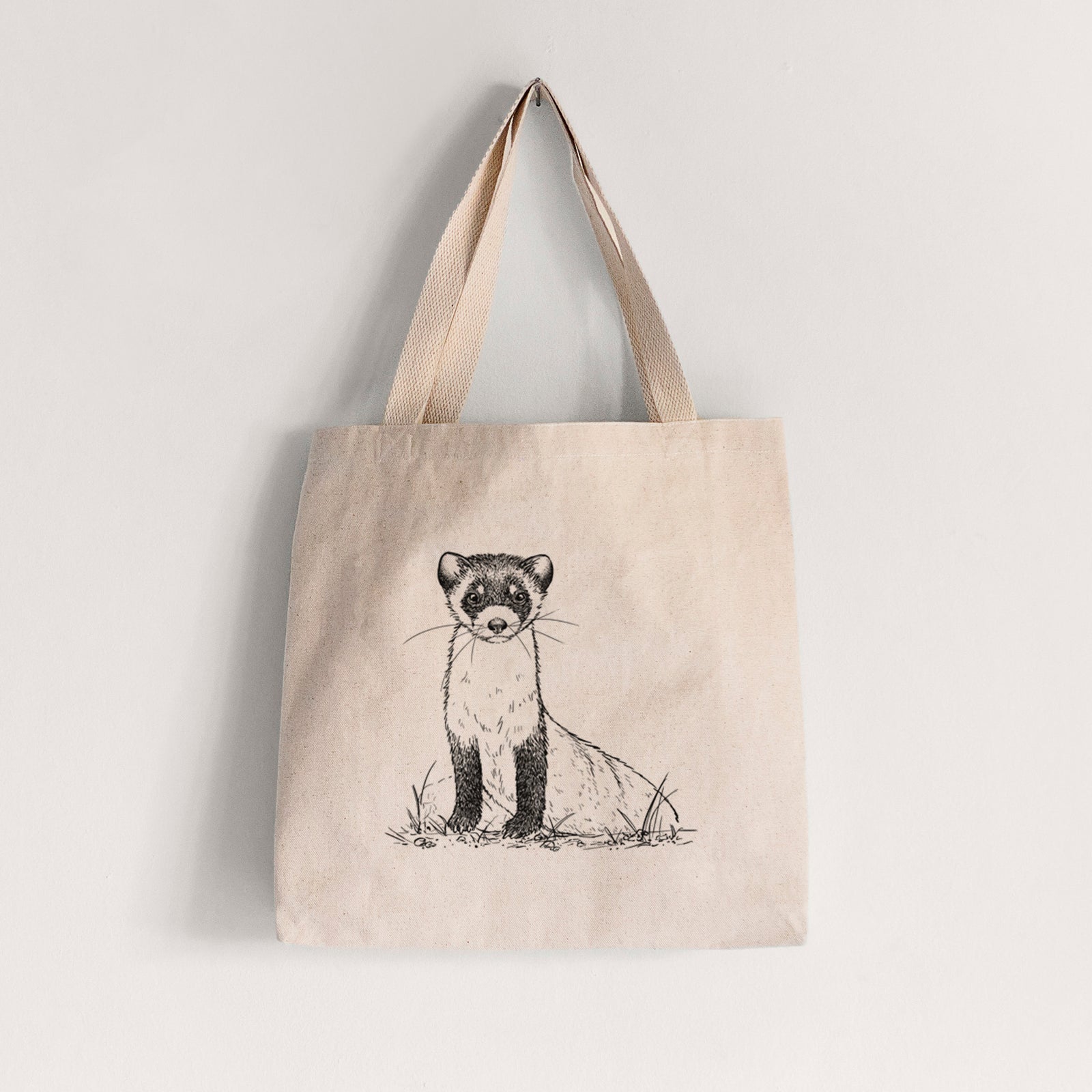 Natural canvas tote bag printed with a detailed black ink illustration of a black-footed ferret sitting on the ground.