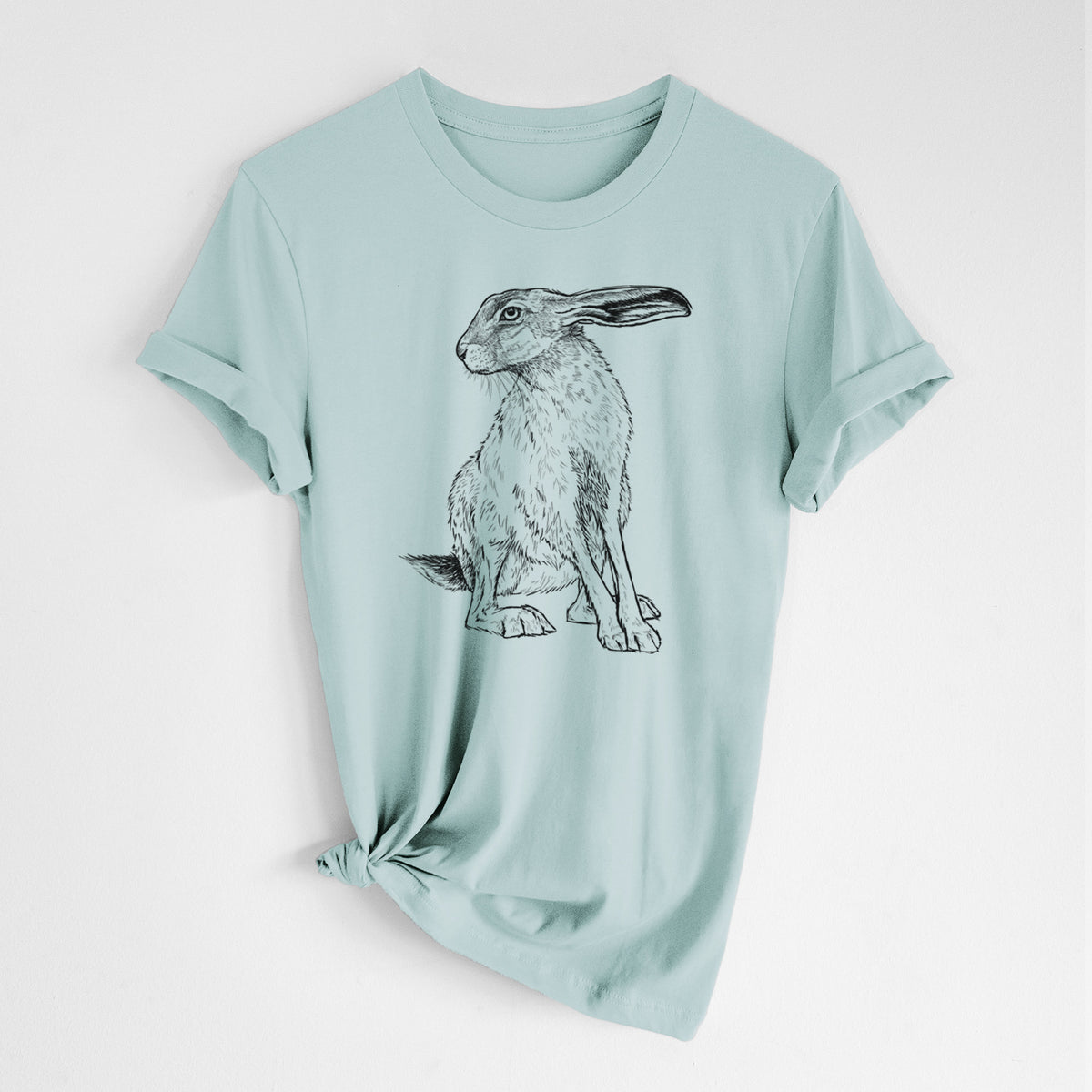 Dusty blue lightweight cotton t-shirt laid flat with the sleeves rolled, printed with a detailed black ink illustration of a black-tailed jackrabbit sitting with long upright ears.