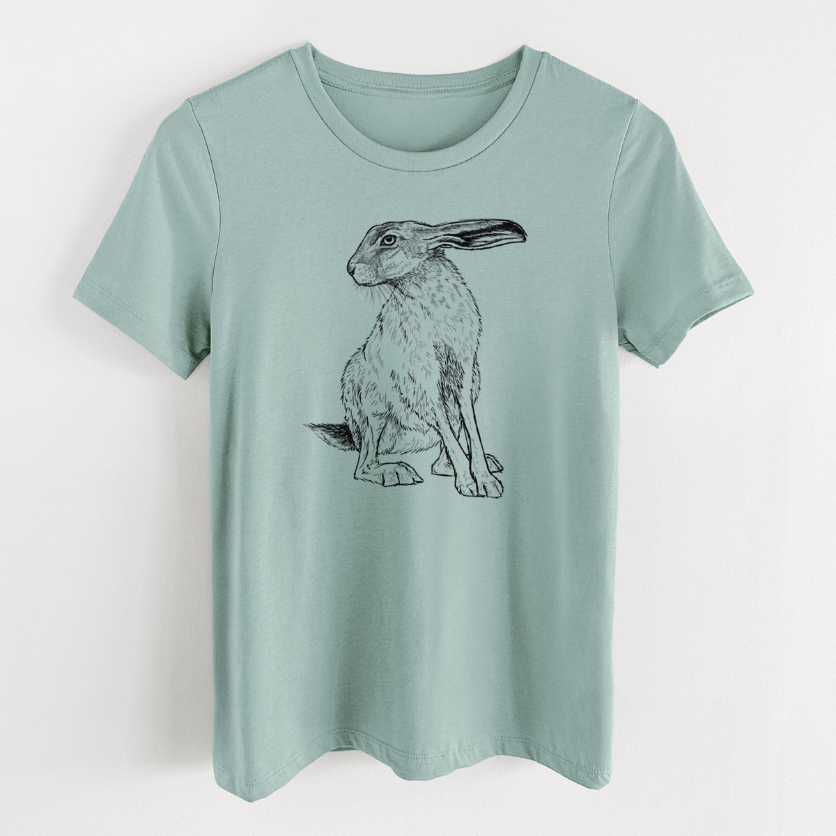 Dusty blue women's relaxed fit cotton t-shirt laid flat, printed with a detailed black ink illustration of a black-tailed jackrabbit sitting with long upright ears.
