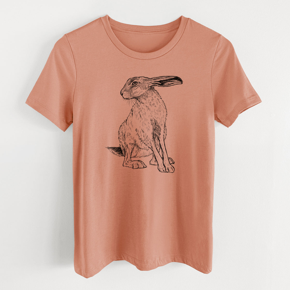 Terracotta orange women's relaxed fit cotton t-shirt laid flat, printed with a detailed black ink illustration of a black-tailed jackrabbit sitting with long upright ears.