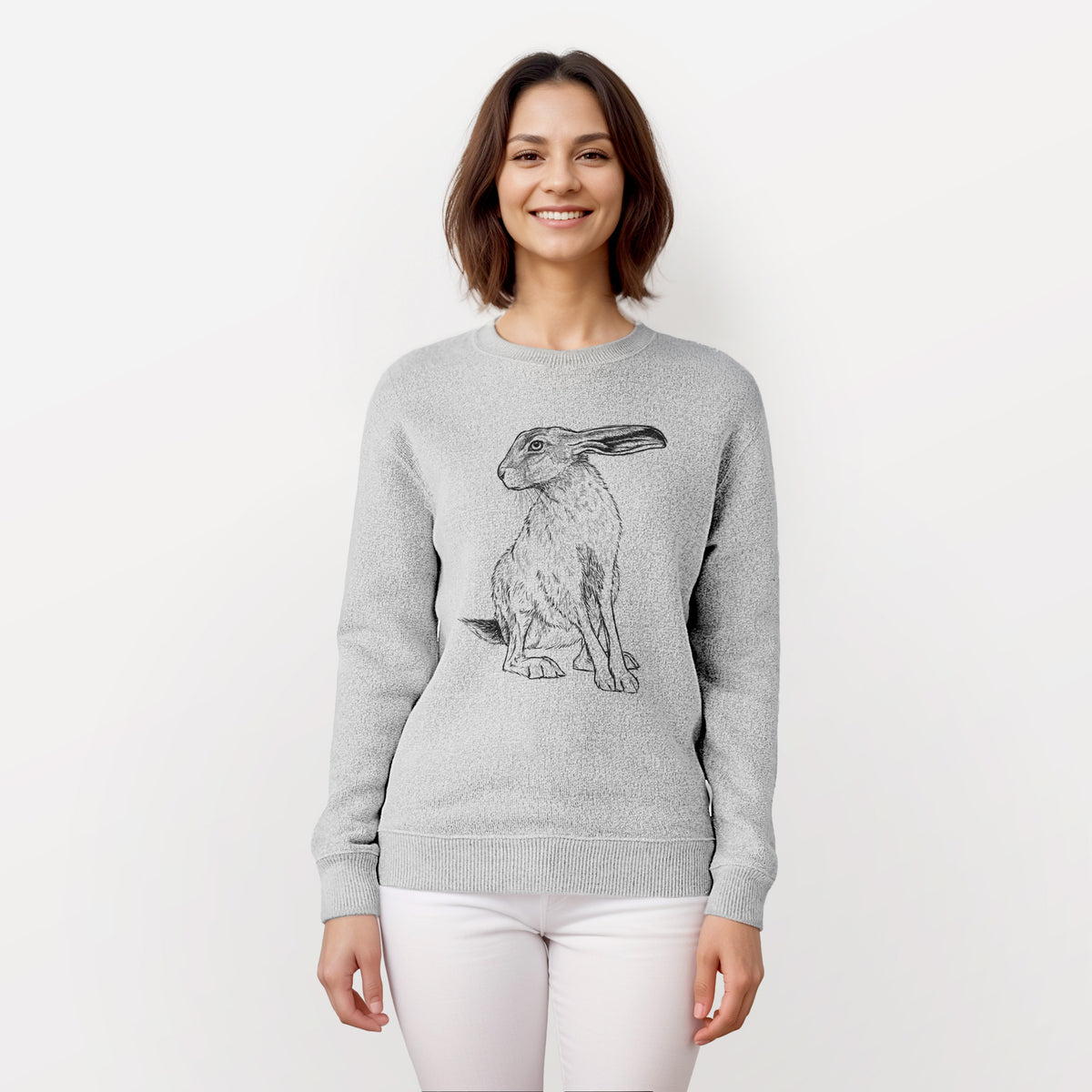 Woman wearing a knit sweatshirt printed with a detailed black ink illustration of a black-tailed jackrabbit sitting with long upright ears.