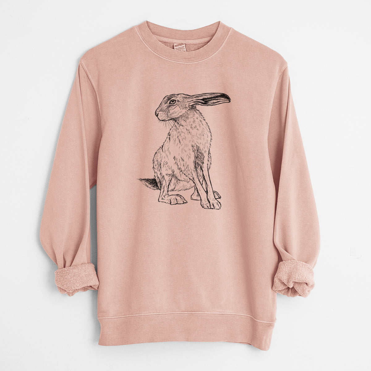 Dusty pink pigment dyed crewneck sweatshirt laid flat with the sleeves rolled, printed with a detailed black ink illustration of a black-tailed jackrabbit sitting with long upright ears.