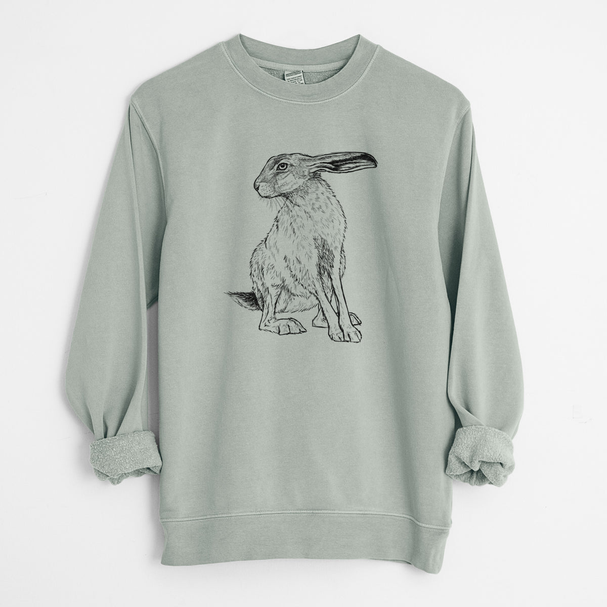 Sage green pigment dyed crewneck sweatshirt laid flat with the sleeves rolled, printed with a detailed black ink illustration of a black-tailed jackrabbit sitting with long upright ears.