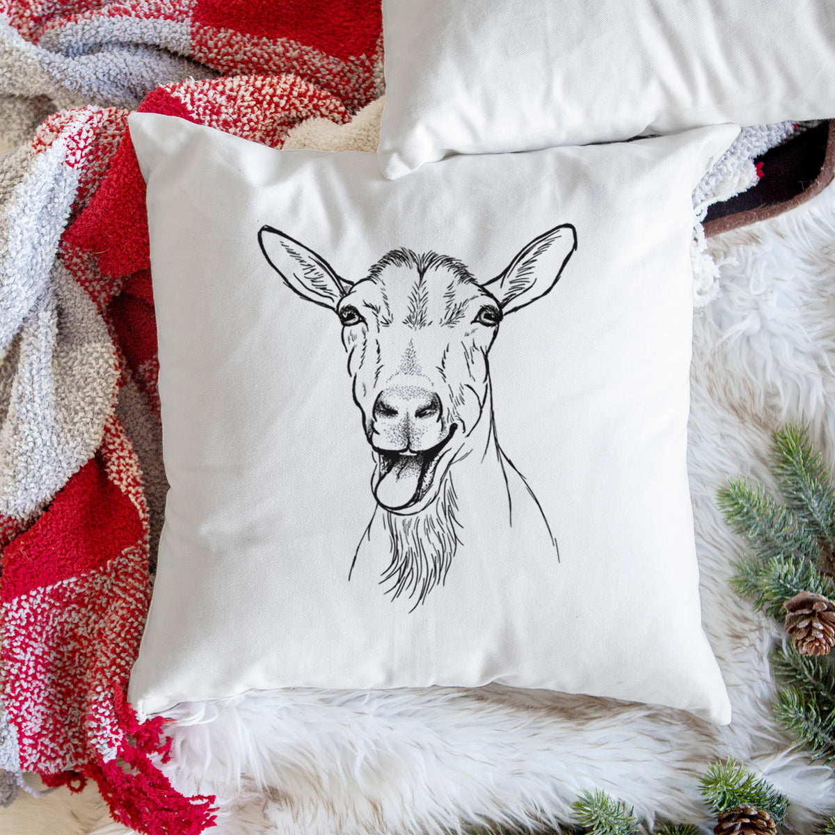White pillow cover printed with a black ink illustration of a goat's head with its mouth open mid-bleat and its tongue out, on a woven chair.