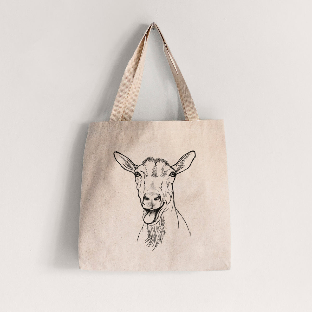 Natural canvas tote bag printed with a black ink illustration of a goat's head with its mouth open mid-bleat and its tongue out.
