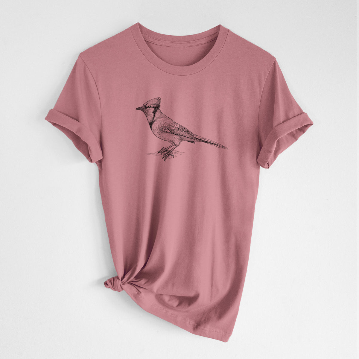 Mauve pink lightweight cotton t-shirt laid flat with the sleeves rolled, printed with a detailed black ink sketch of a blue jay perched with its crest raised.