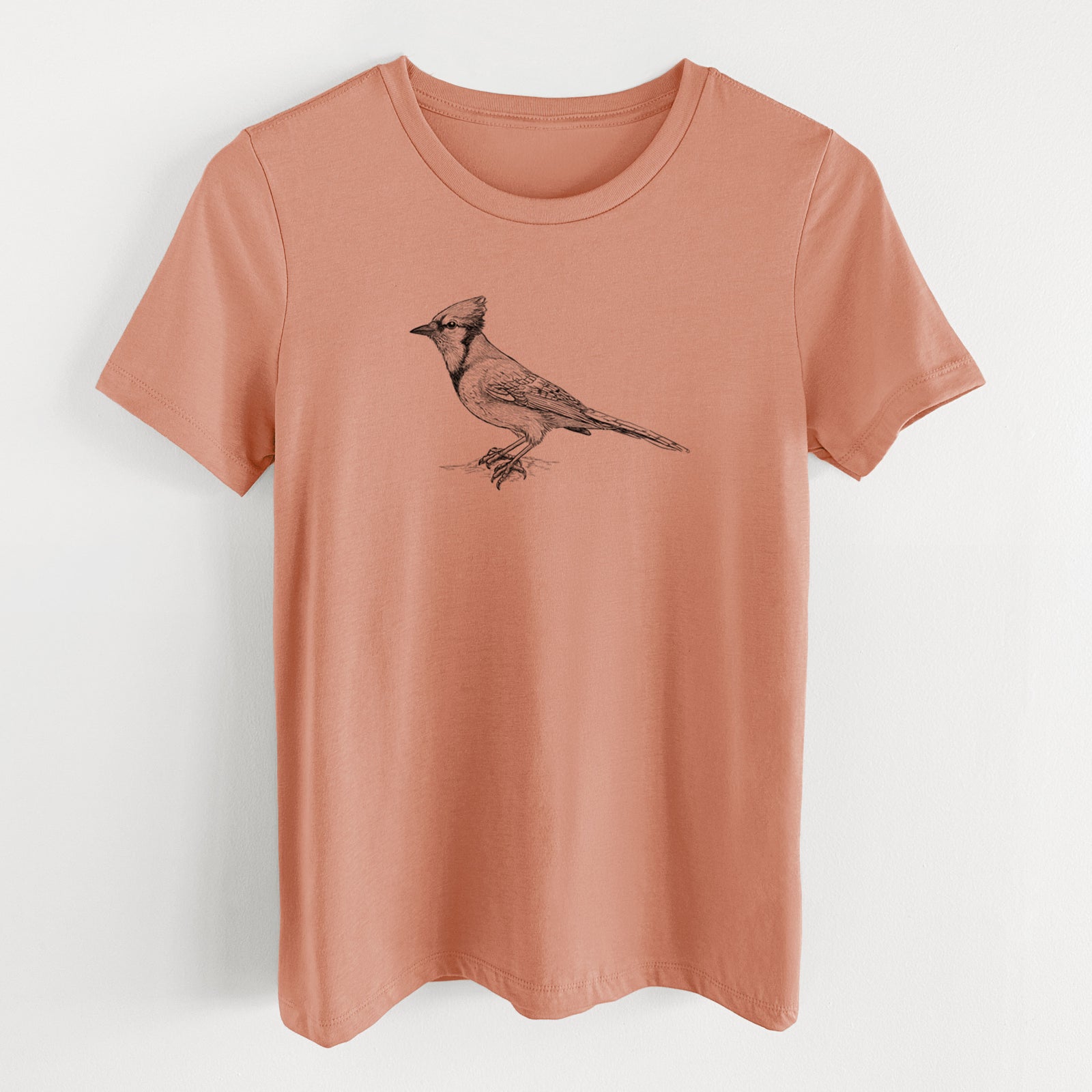 Terracotta orange women's relaxed fit cotton t-shirt laid flat, printed with a detailed black ink sketch of a blue jay perched with its crest raised.