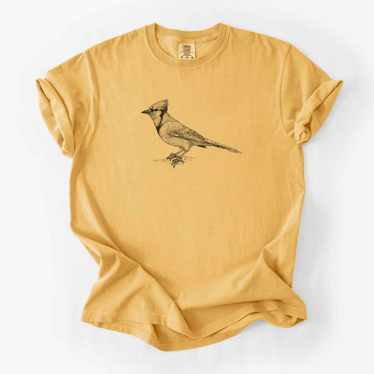 Golden wheat yellow Comfort Colors t-shirt laid flat, printed with a detailed black ink sketch of a blue jay perched with its crest raised.