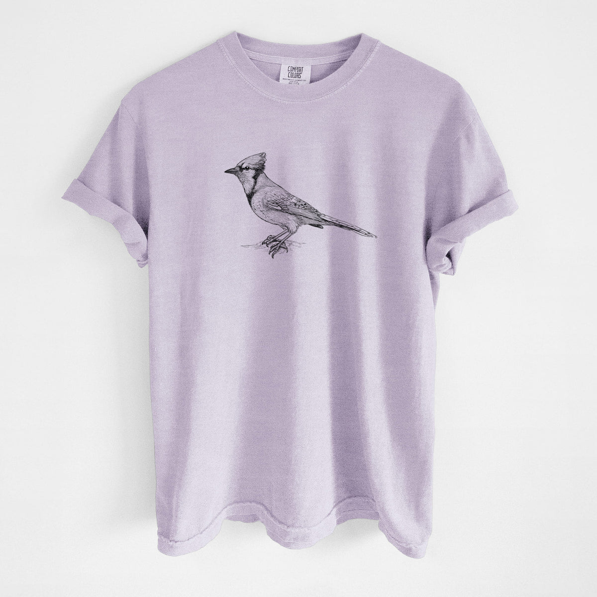 Orchid purple Comfort Colors t-shirt laid flat, printed with a detailed black ink sketch of a blue jay perched with its crest raised.