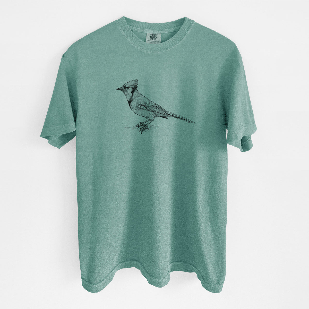 Reef green Comfort Colors t-shirt laid flat, printed with a detailed black ink sketch of a blue jay perched with its crest raised.