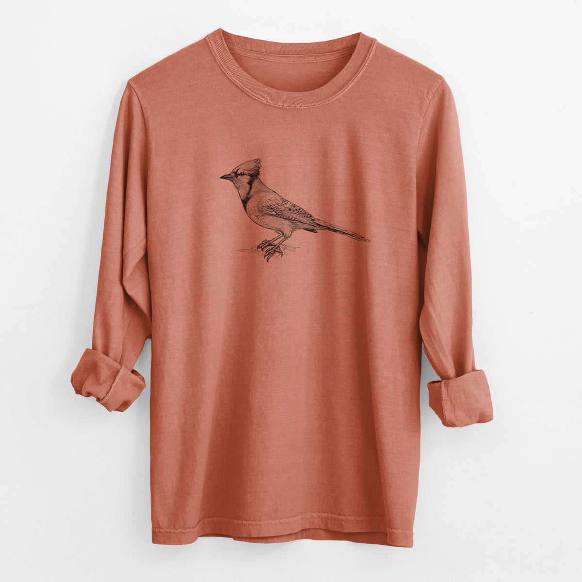 Yam burnt orange Comfort Colors long sleeve shirt laid flat with the cuffs rolled, printed with a detailed black ink sketch of a blue jay perched with its crest raised.