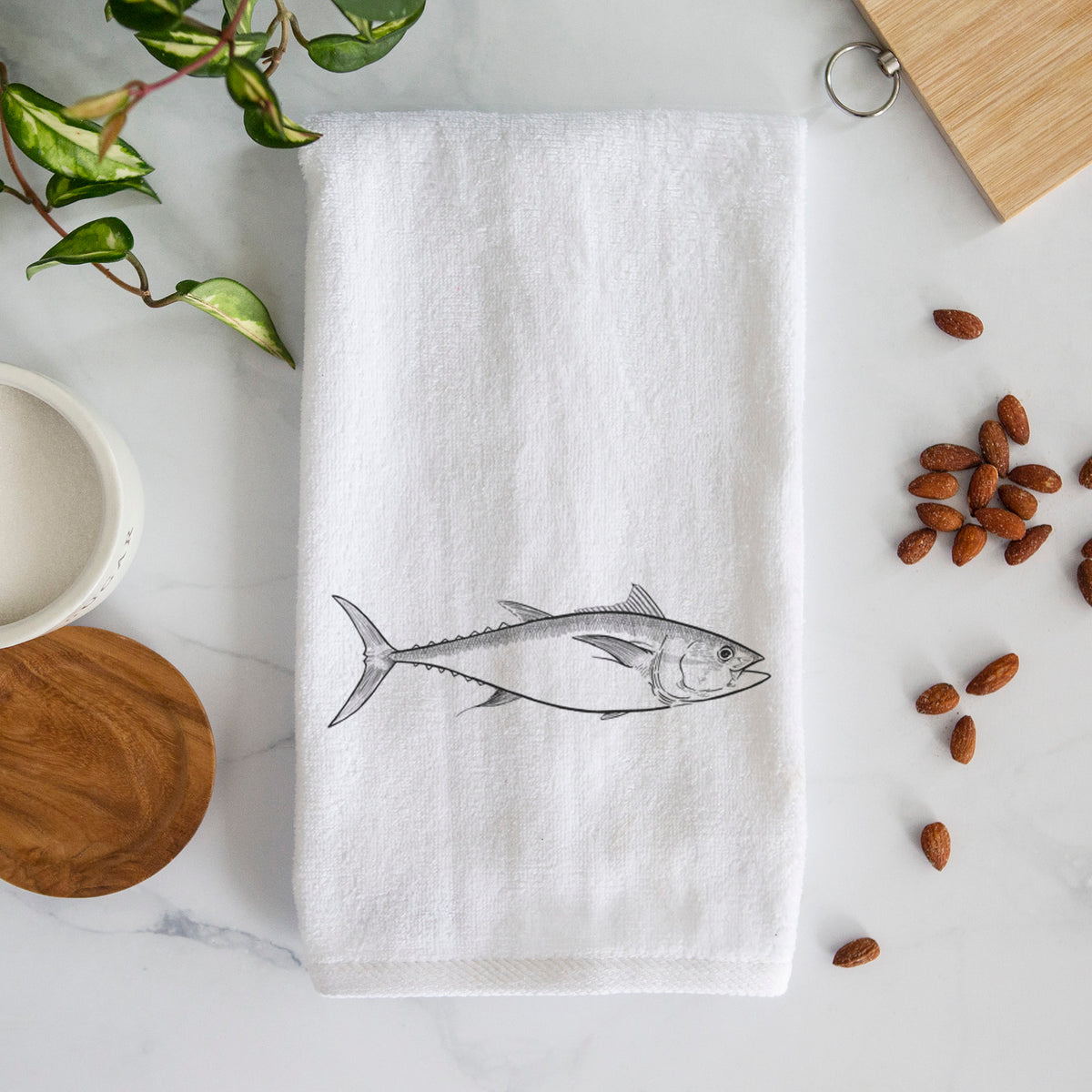White hand towel printed with a black ink line drawing of a bluefin tuna swimming.