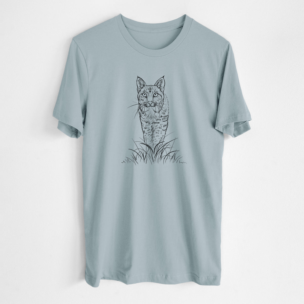 Vintage denim lightweight cotton t-shirt laid flat, printed with a black ink illustration of a bobcat standing in tall grass, facing forward.
