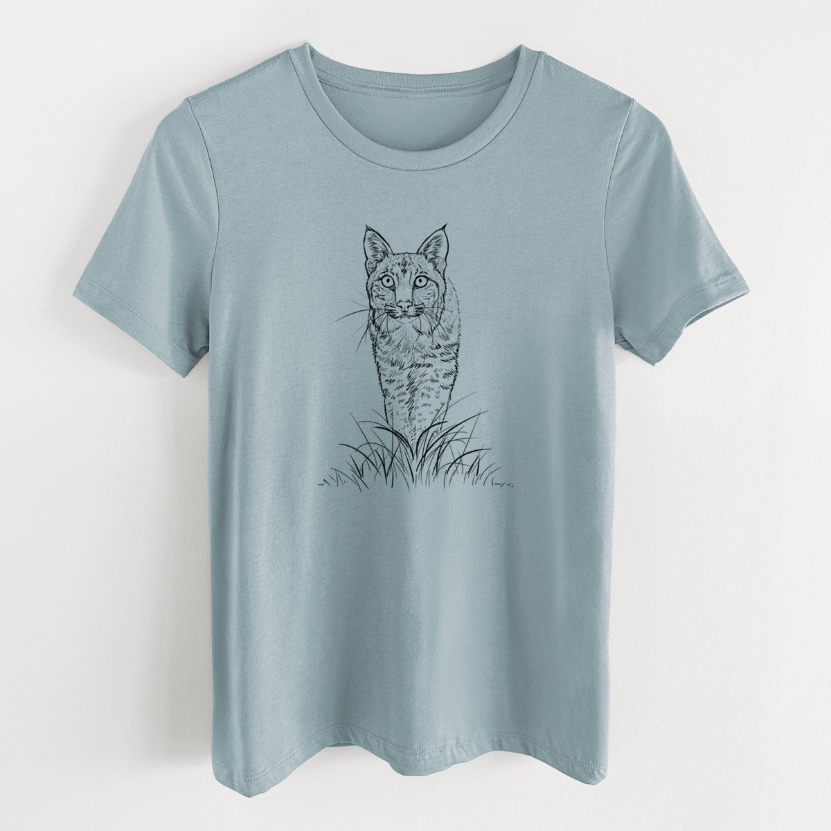 Vintage denim women's relaxed fit cotton t-shirt laid flat, printed with a black ink illustration of a bobcat standing in tall grass, facing forward.