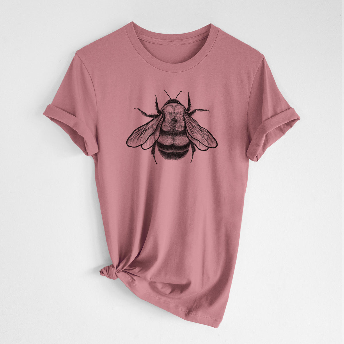 Mauve pink lightweight cotton t-shirt laid flat with the sleeves rolled, printed with a detailed black ink illustration of a rusty patched bumble bee with its wings spread, seen from above.