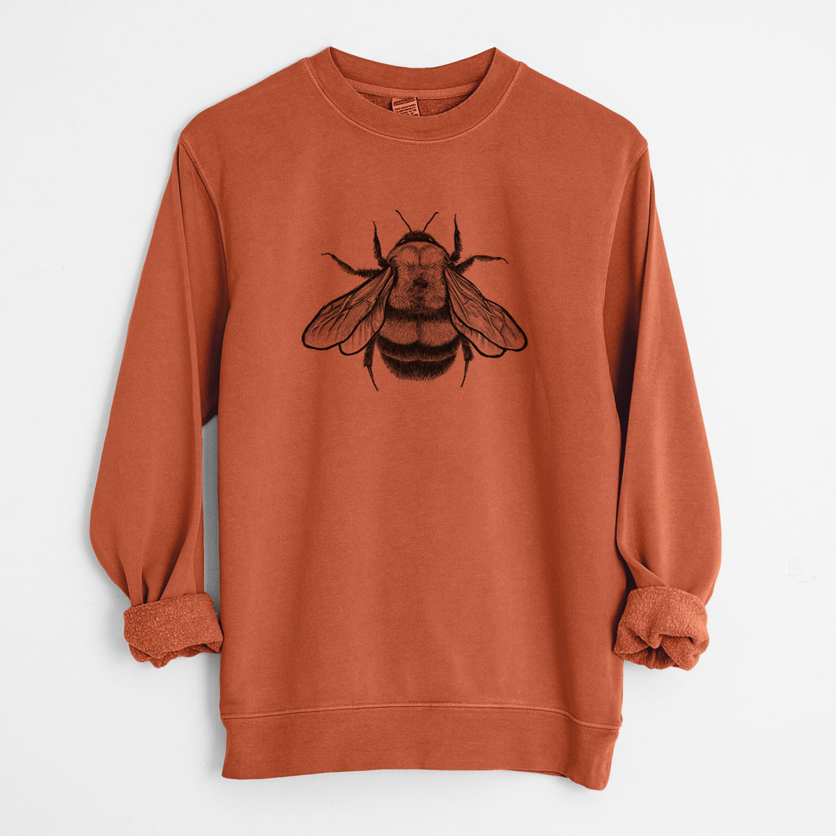 Amber orange pigment dyed crewneck sweatshirt laid flat with the sleeves rolled, printed with a detailed black ink illustration of a rusty patched bumble bee with its wings spread, seen from above.