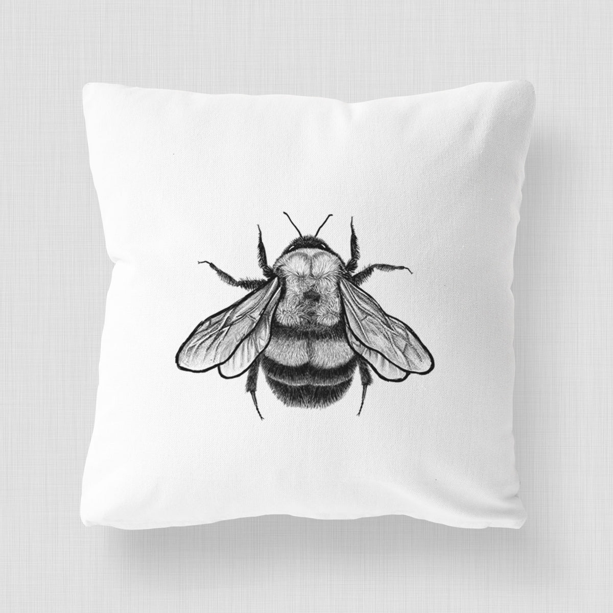 White pillow cover printed with a detailed black ink illustration of a rusty patched bumble bee with its wings spread, seen from above.