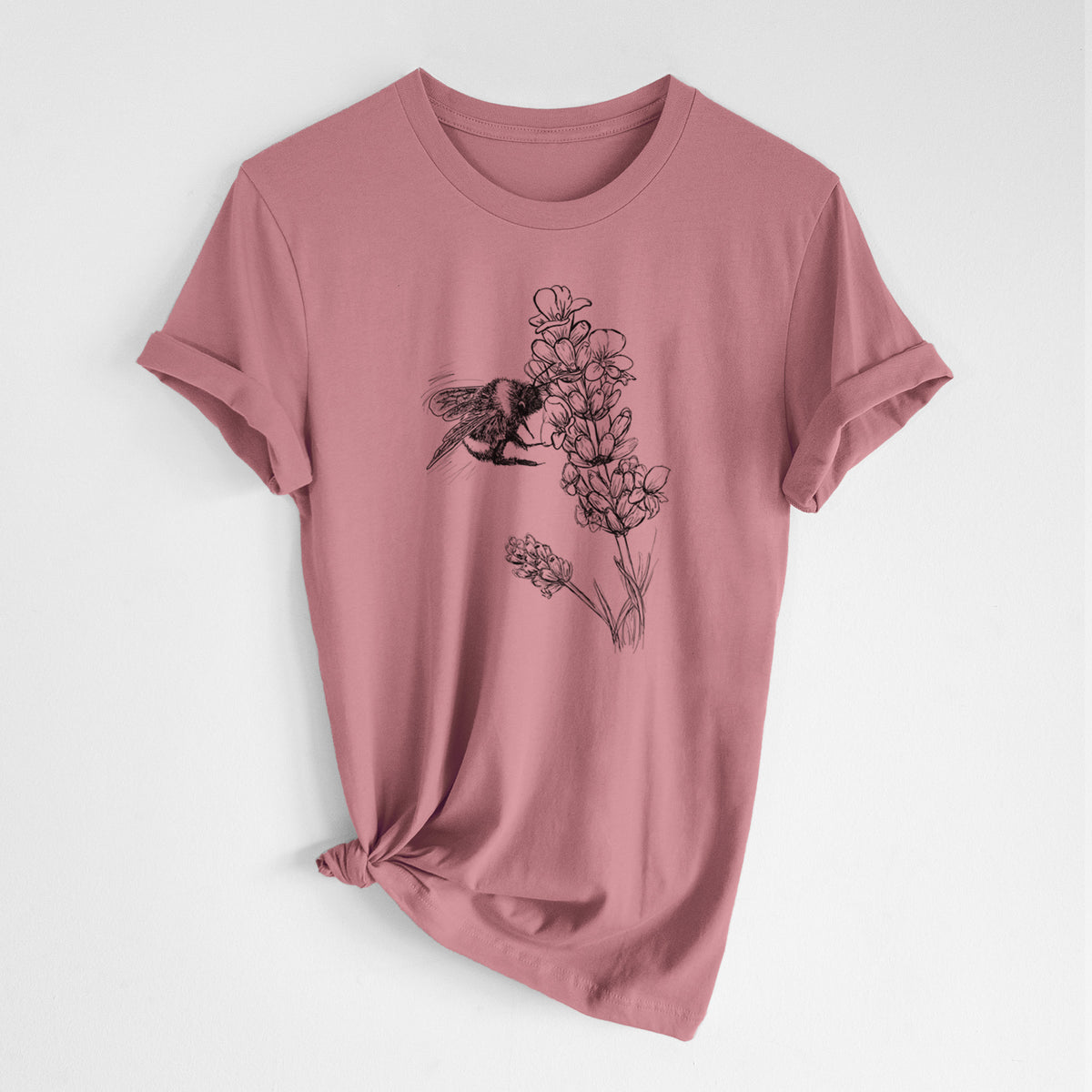 Mauve pink lightweight cotton t-shirt laid flat with the sleeves rolled, printed with a black ink illustration of a bumble bee visiting a sprig of lavender.