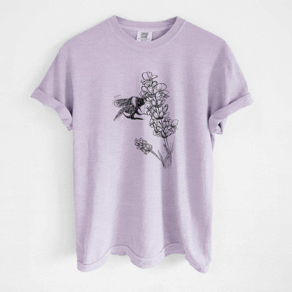 Orchid purple Comfort Colors t-shirt laid flat, printed with a black ink illustration of a bumble bee visiting a sprig of lavender.