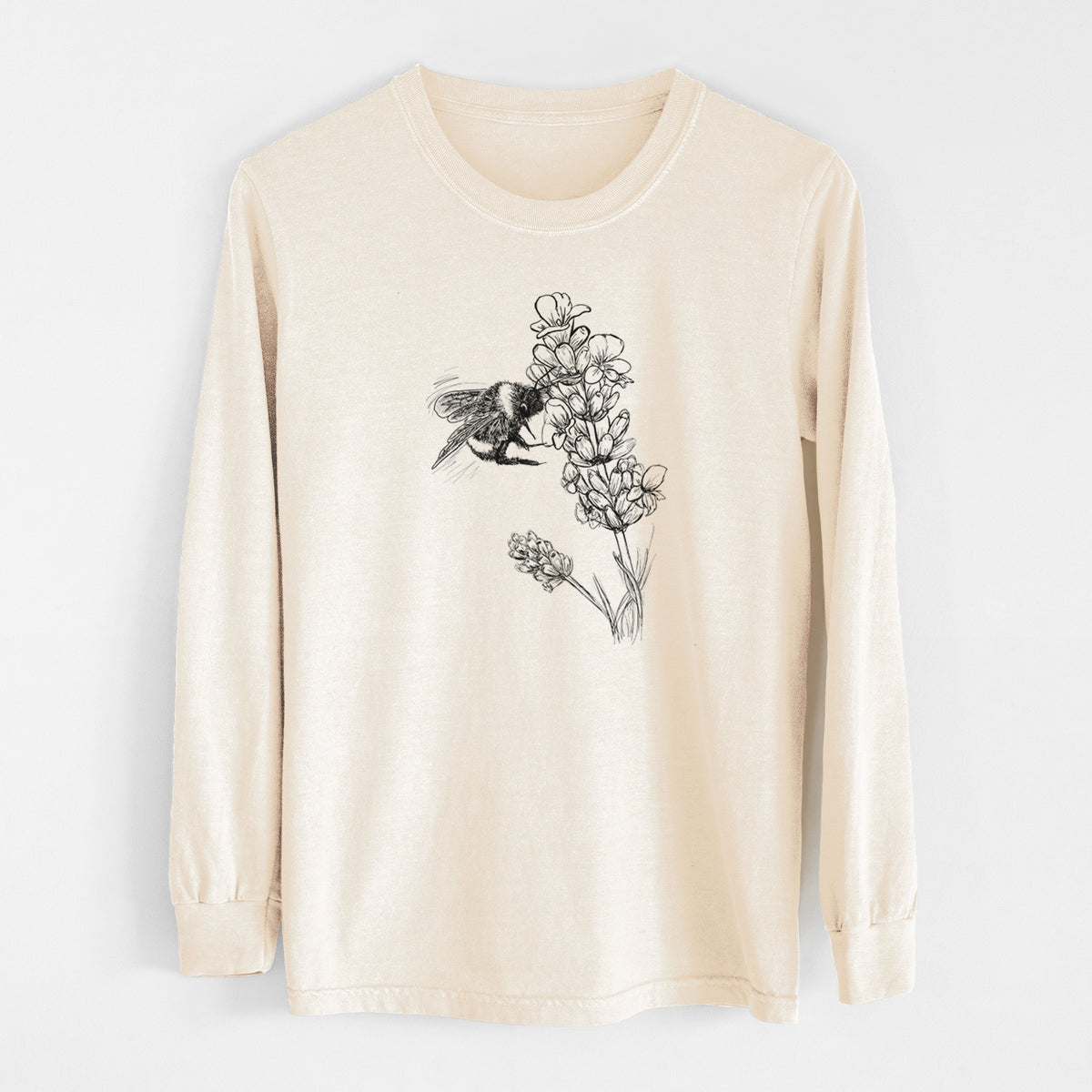 Ivory Comfort Colors long sleeve shirt laid flat, printed with a black ink illustration of a bumble bee visiting a sprig of lavender.