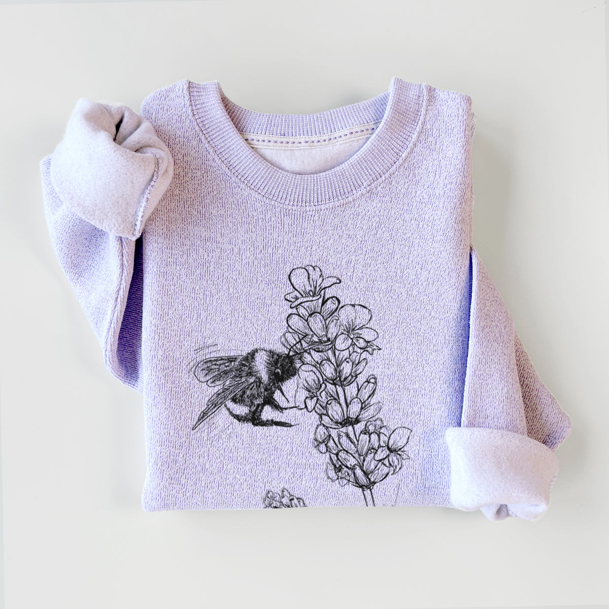 Ice purple knit sweatshirt printed with a black ink illustration of a bumble bee visiting a sprig of lavender, styled flat.