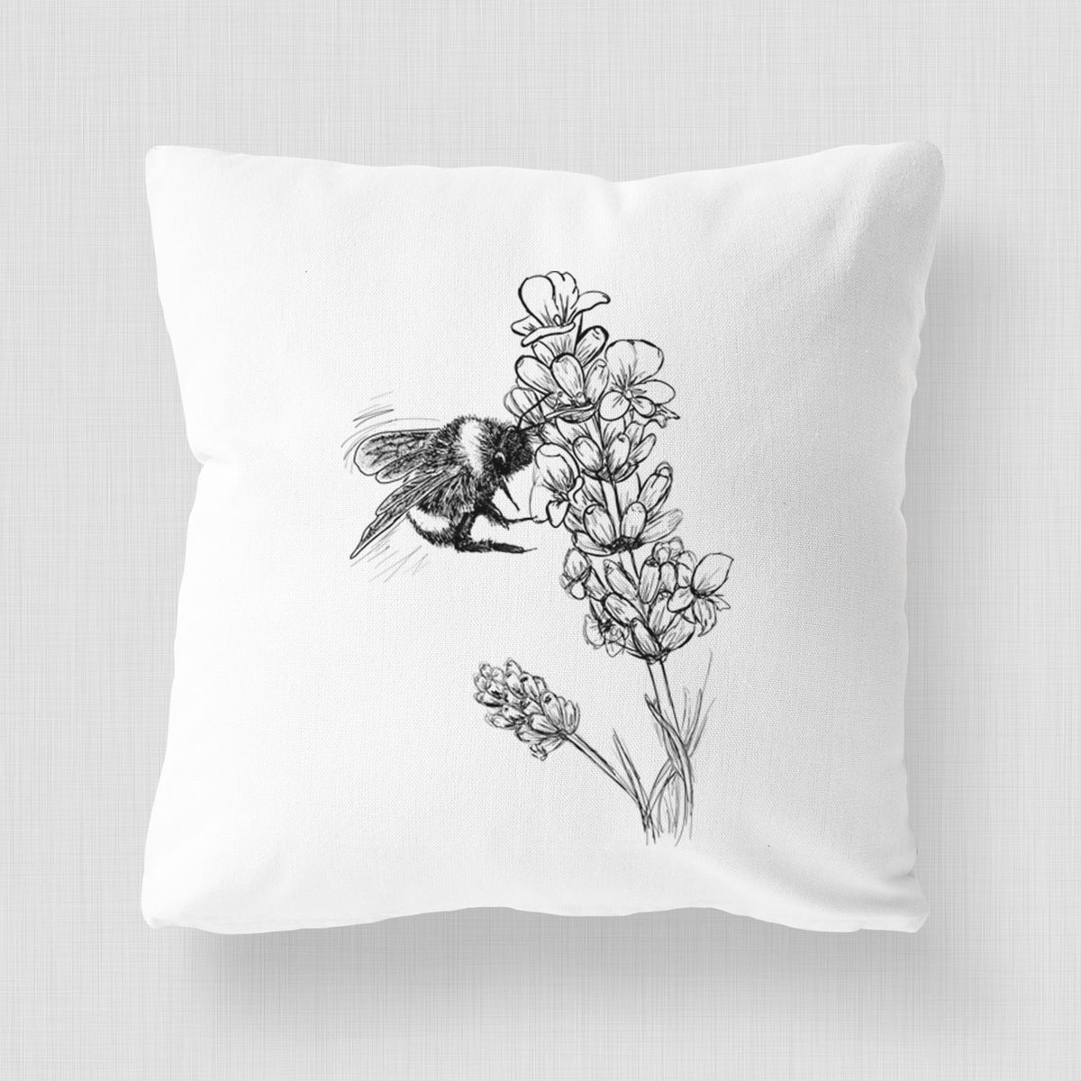 White pillow cover printed with a black ink illustration of a bumble bee visiting a sprig of lavender.