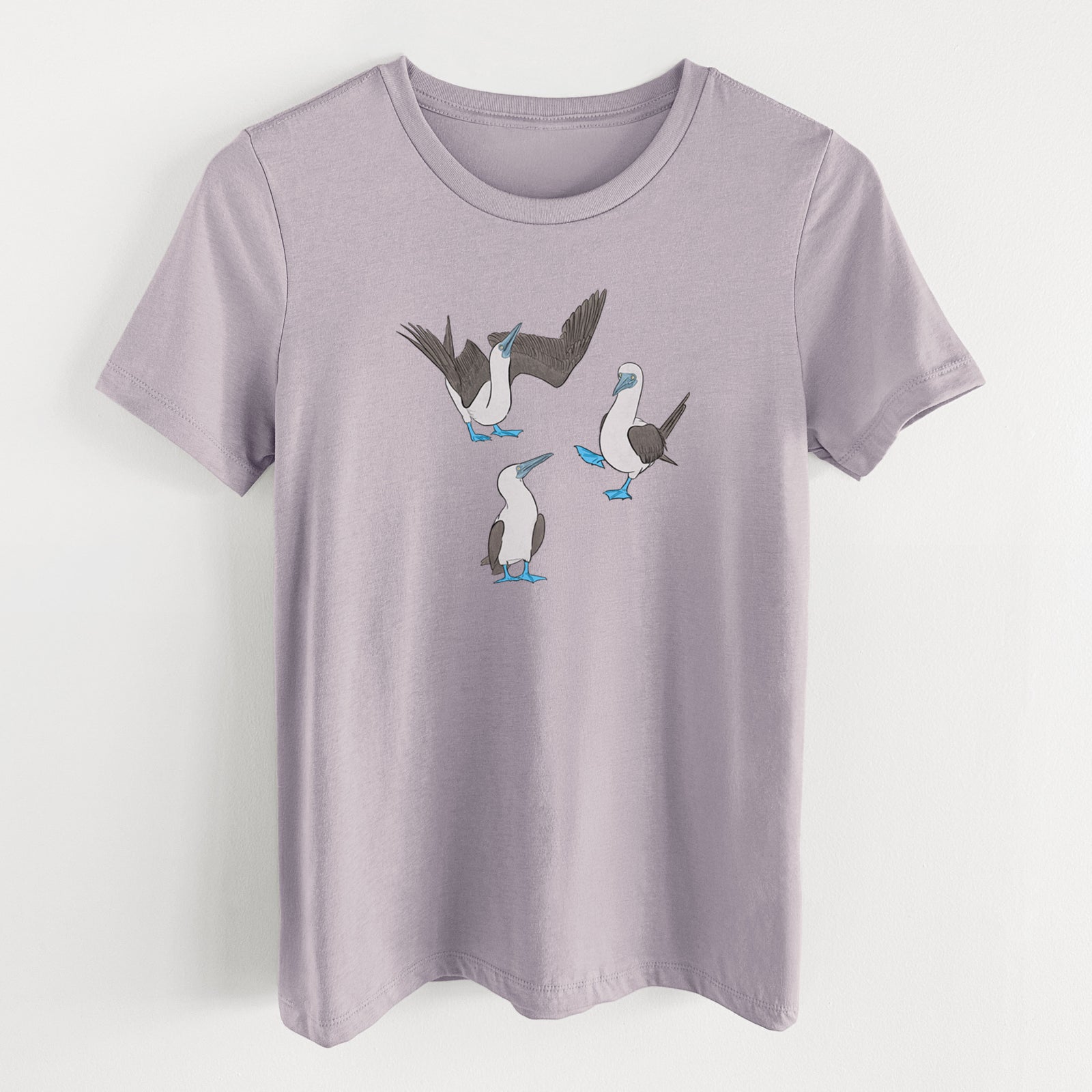 Light violet women's relaxed fit cotton t-shirt laid flat, printed with a full-color illustration of three blue-footed boobies, one with its wings spread.