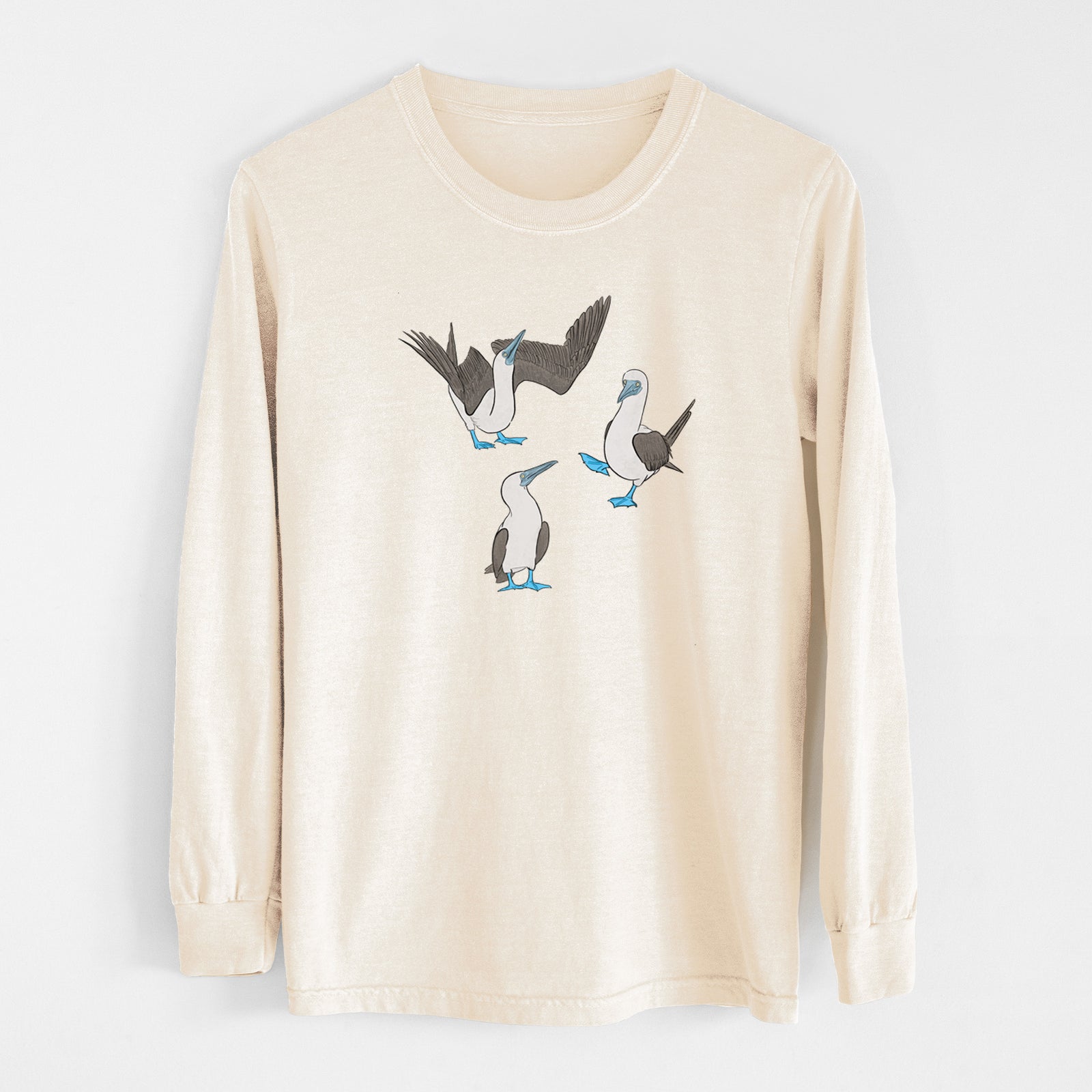 Ivory Comfort Colors long sleeve shirt laid flat, printed with a full-color illustration of three blue-footed boobies, one with its wings spread.