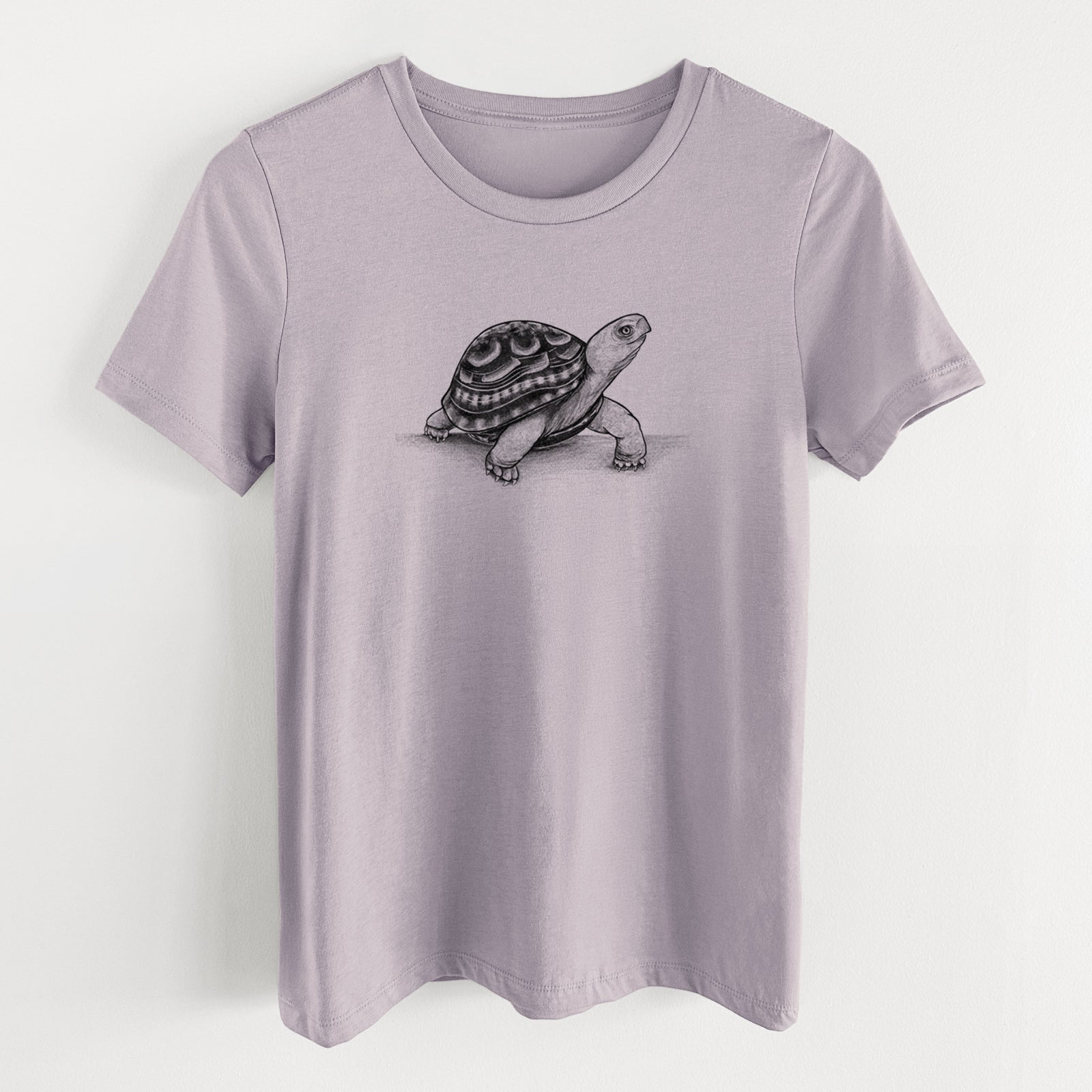 Light violet women's relaxed fit cotton t-shirt laid flat, printed with a detailed black ink illustration of an eastern box turtle walking.