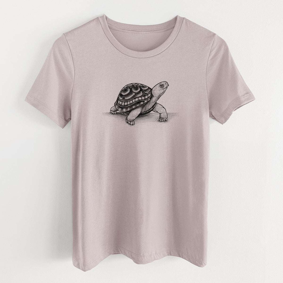 Pink gravel women's relaxed fit cotton t-shirt laid flat, printed with a detailed black ink illustration of an eastern box turtle walking.