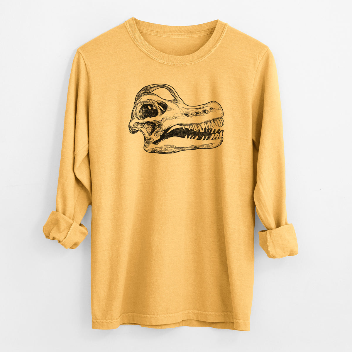 Golden wheat yellow Comfort Colors long sleeve shirt laid flat with the cuffs rolled, printed with a detailed black ink illustration of a Brachiosaurus skull.