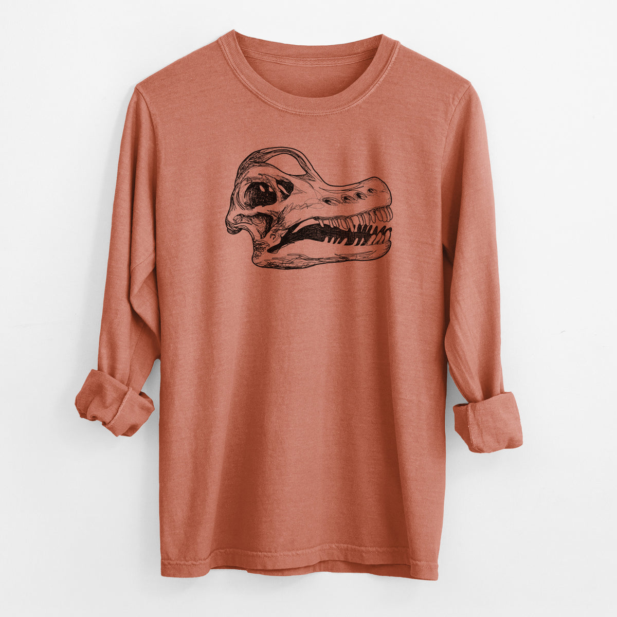 Yam burnt orange Comfort Colors long sleeve shirt laid flat with the cuffs rolled, printed with a detailed black ink illustration of a Brachiosaurus skull.