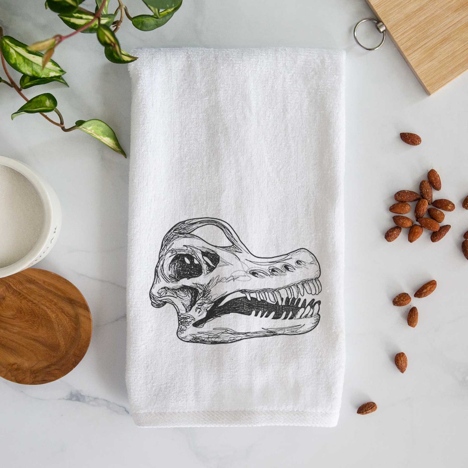 White hand towel printed with a detailed black ink illustration of a Brachiosaurus skull.