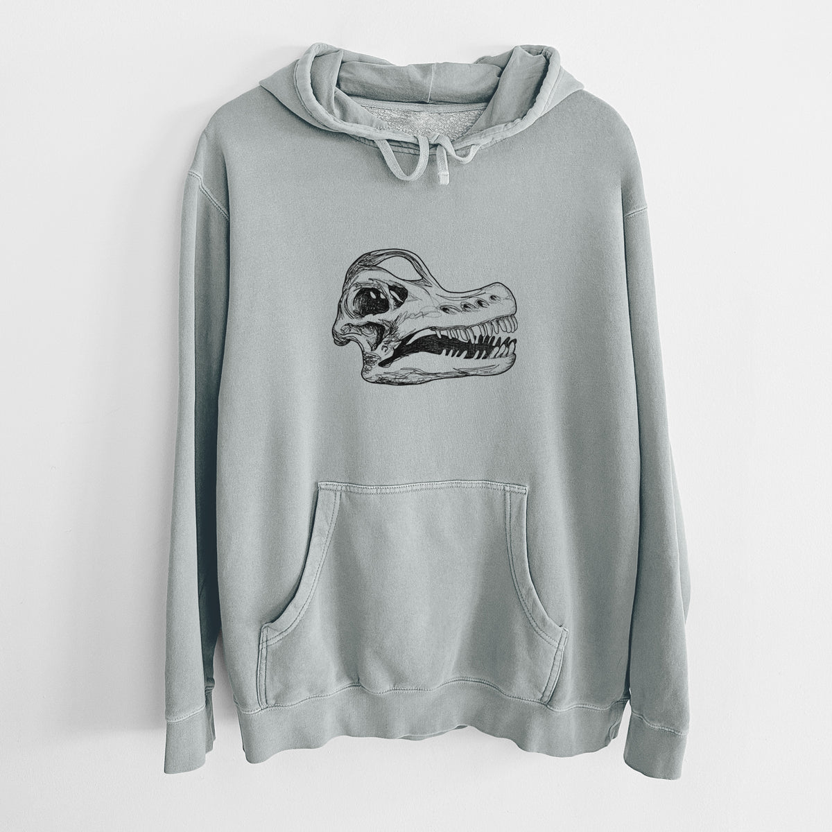 Sage green pigment dyed hoodie laid flat, printed with a detailed black ink illustration of a Brachiosaurus skull.