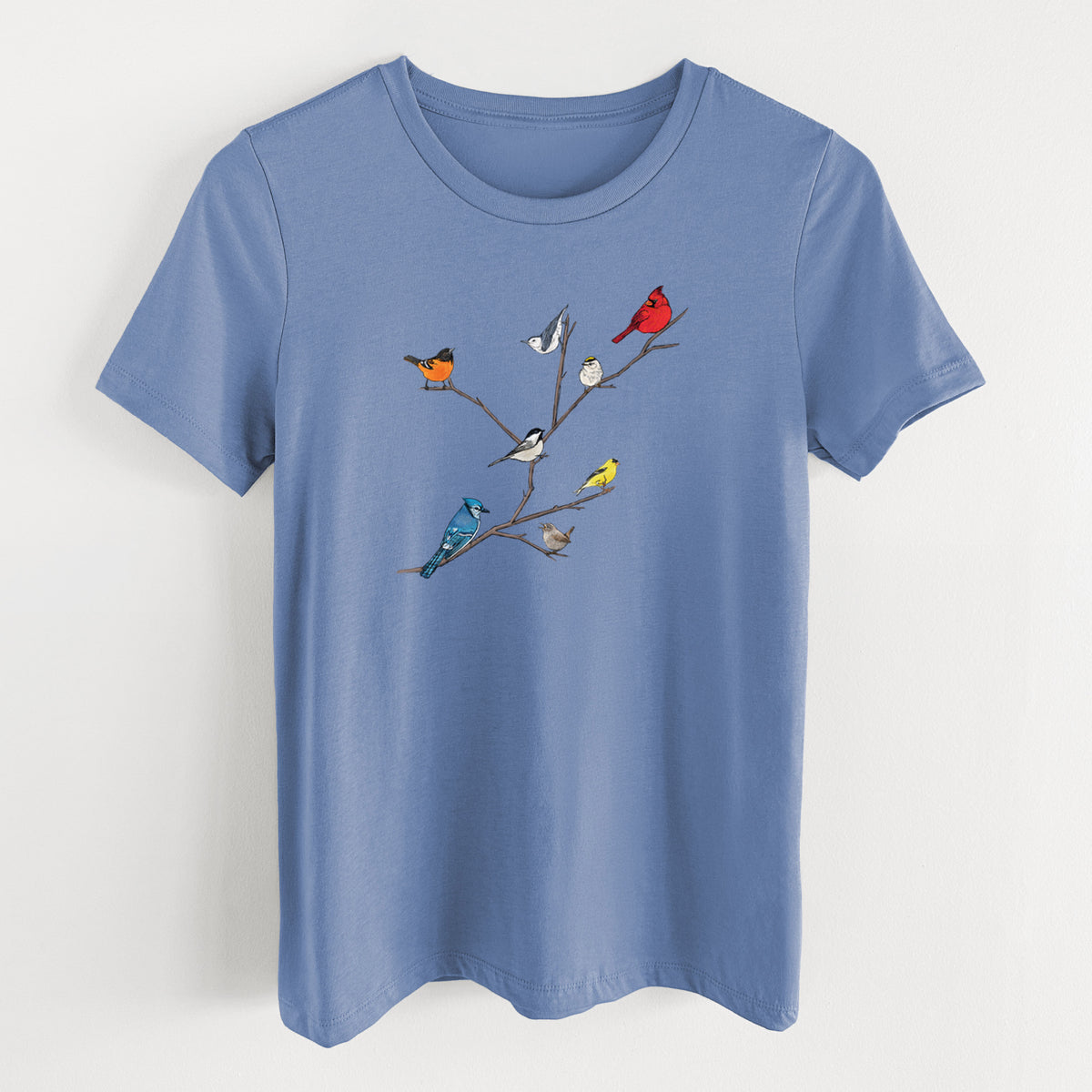 Blue bell women's relaxed fit cotton t-shirt laid flat, printed with a full-color illustration of backyard birds, including a cardinal, blue jay, goldfinch and robin, perched on bare branches.