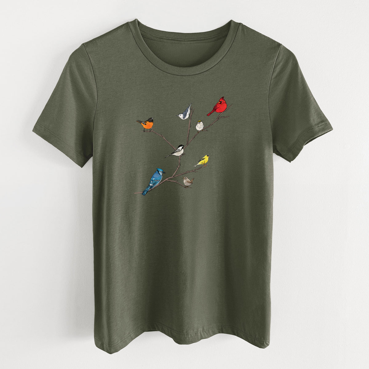 Military green women's relaxed fit cotton t-shirt laid flat, printed with a full-color illustration of backyard birds, including a cardinal, blue jay, goldfinch and robin, perched on bare branches.