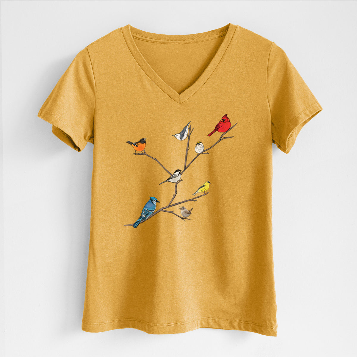 Honeycomb yellow women's relaxed fit cotton V-neck t-shirt laid flat, printed with a full-color illustration of backyard birds, including a cardinal, blue jay, goldfinch and robin, perched on bare branches.